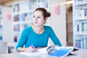 college student in a library (shallow DOF; color to